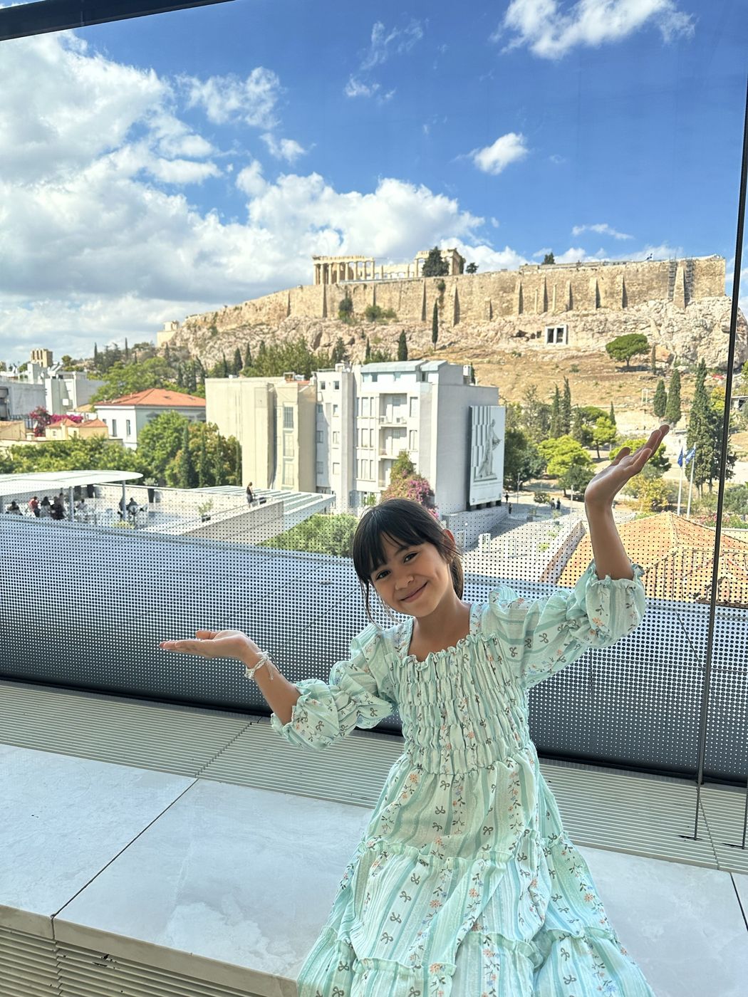 Olivia posing on the Acropolis Museum terrace with the Acropolis behind her