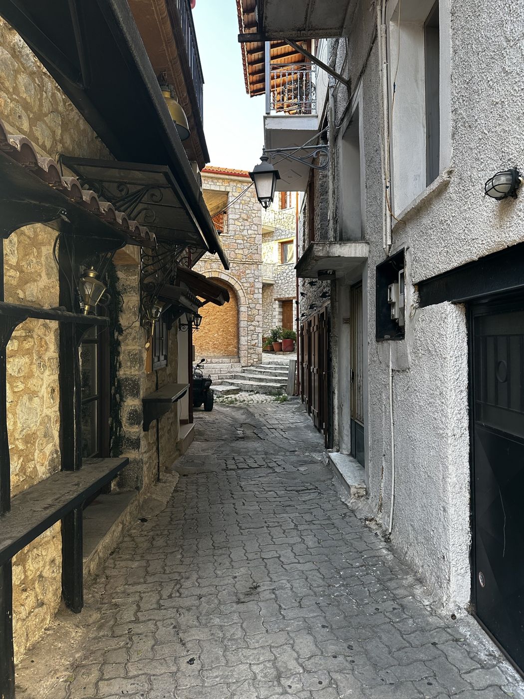 A quiet cobblestone alley between stone houses in Arachova