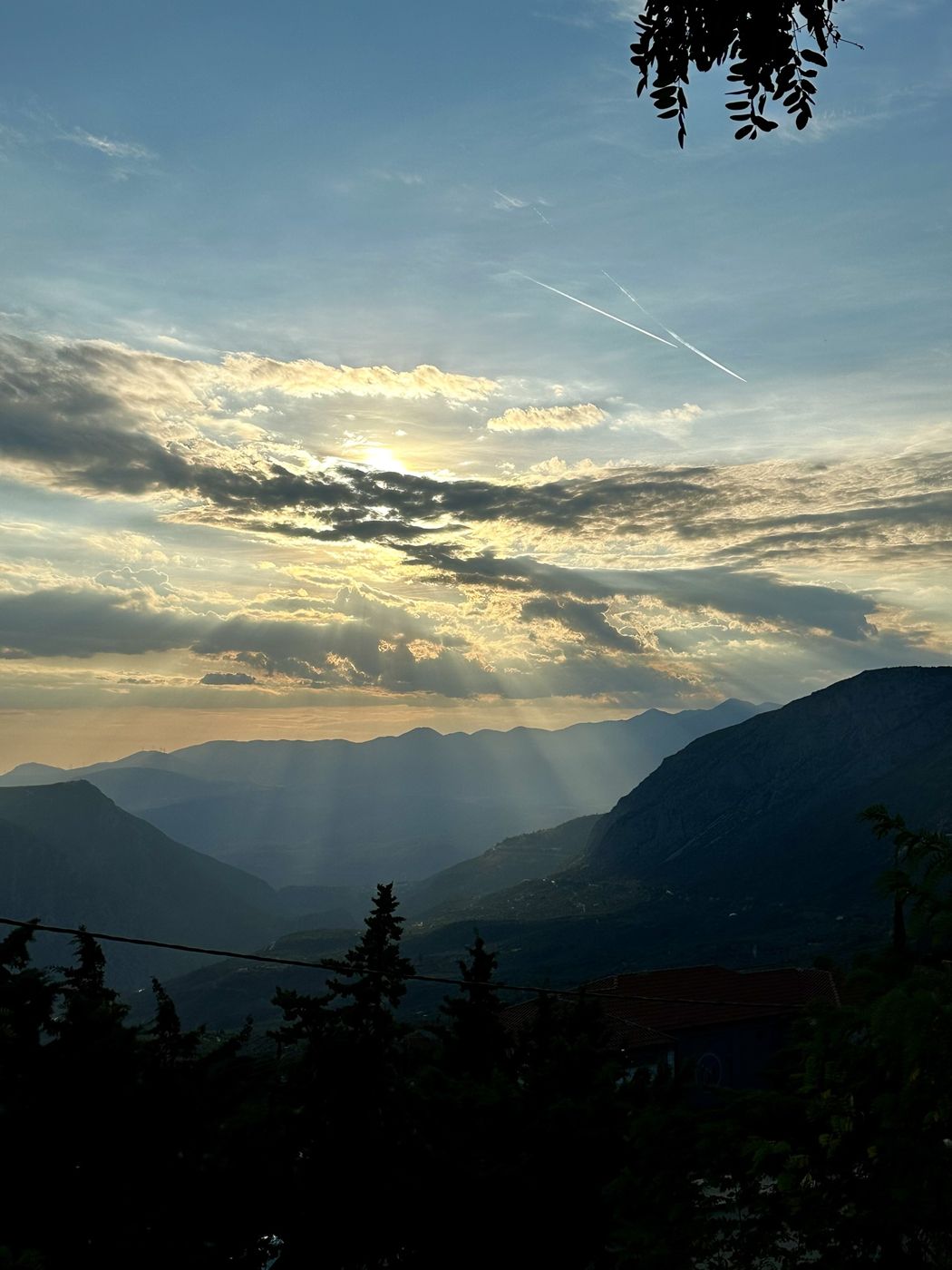 Sun rays breaking through clouds over the mountains near Arachova