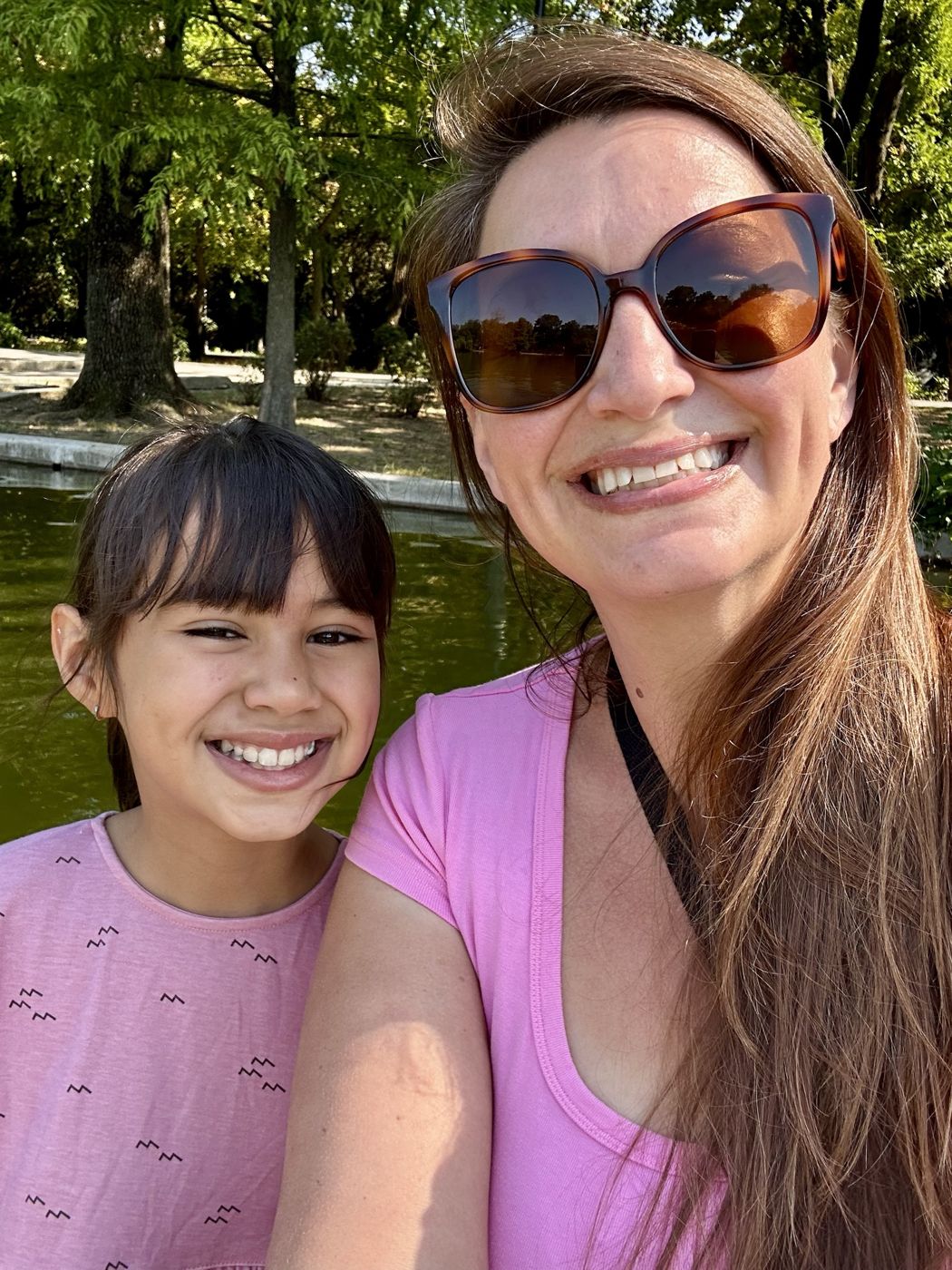 Brittany and Olivia smiling together by the water in Cișmigiu Gardens