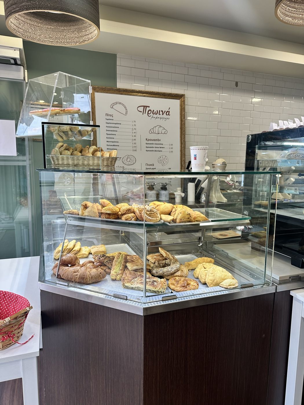 A bakery case full of Greek savory pastries in Itea