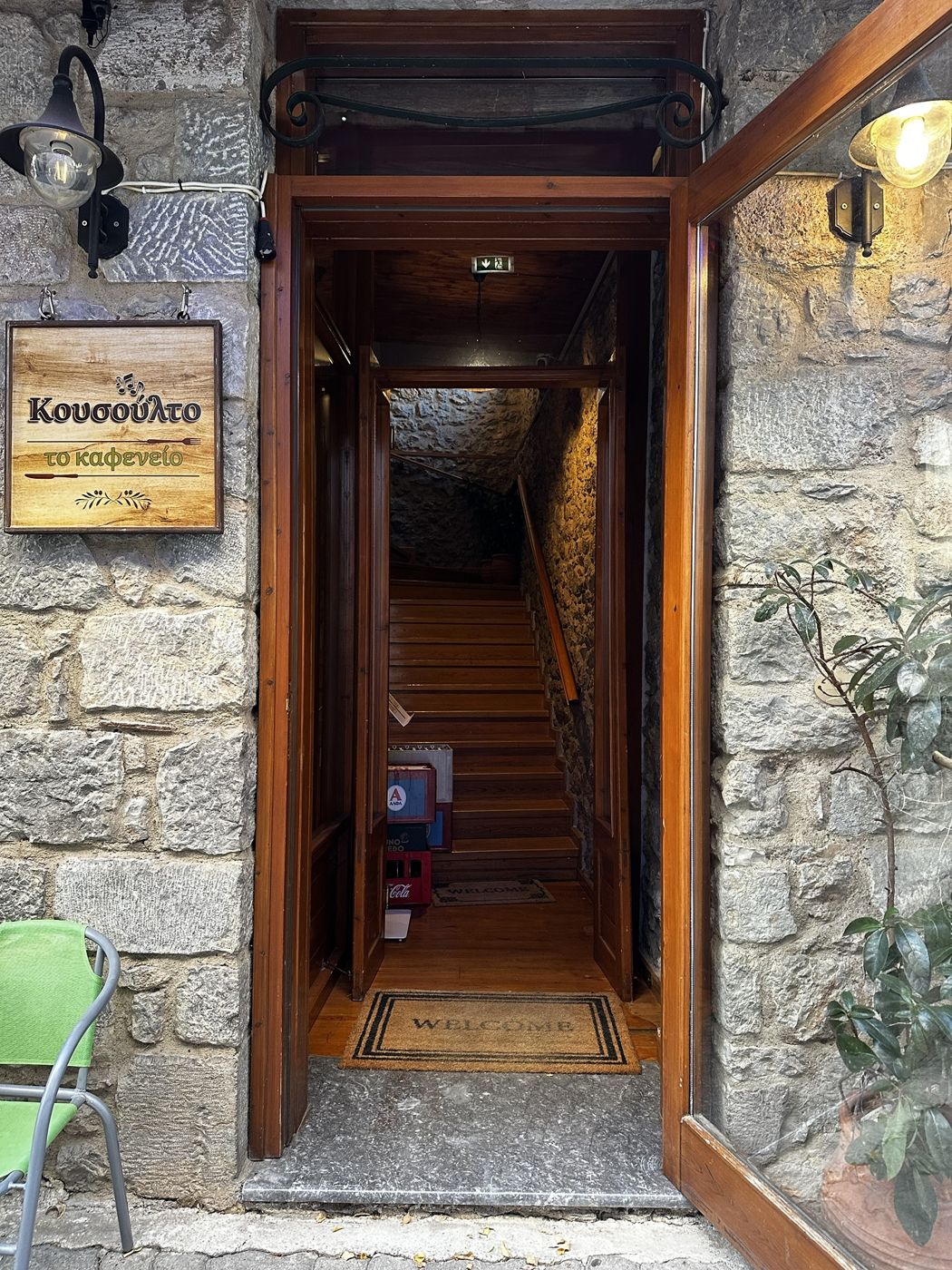 The stone entrance of Kousoulto in Arachova, with its wooden sign and staircase